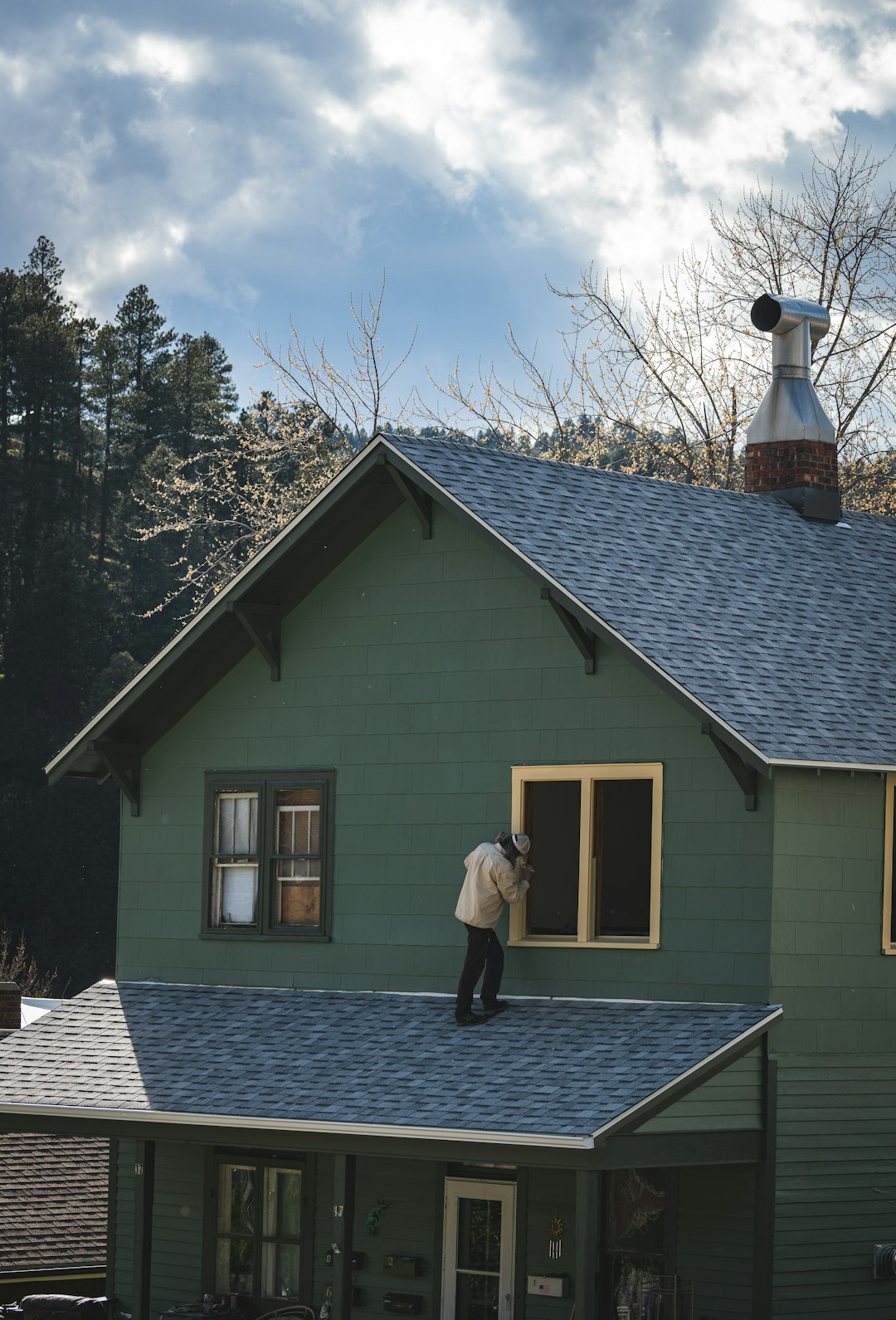 person-on-roof-painting-a-house-window-5esnyi7xvfq